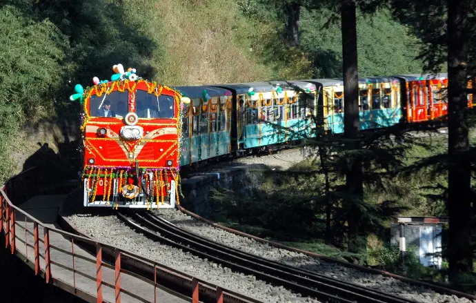 Shimla toy train climbing through snowy hills - Mountain Junkey
