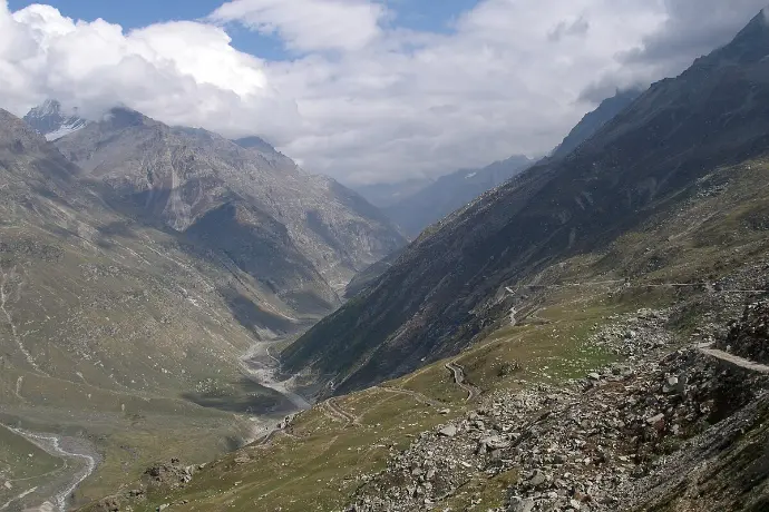 Panoramic view of Ratang Pass showing the transition from lush Kullu Valley to barren Lahaul landscape - Mountain Junkey