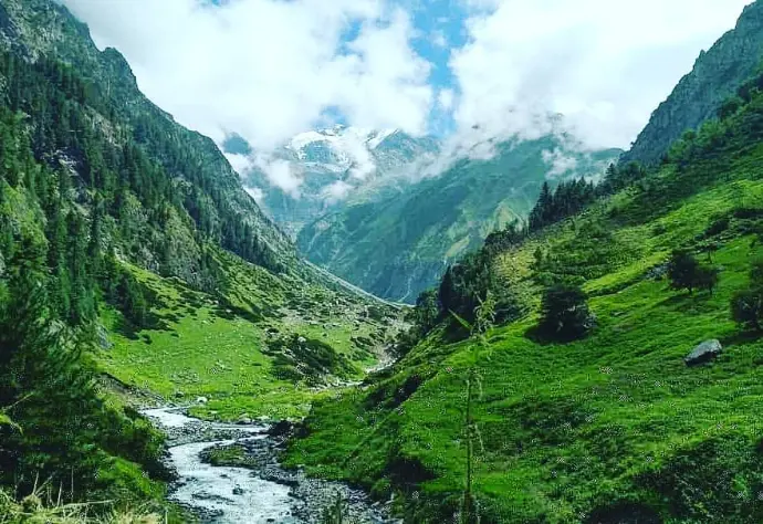 Trail leading to Kugti glacier caves through alpine meadow and moraine fields - Mountain Junkey