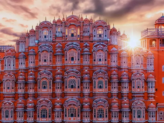 Pink sandstone facade of Hawa Mahal palace in Jaipur at sunset - Mountain Junkey
