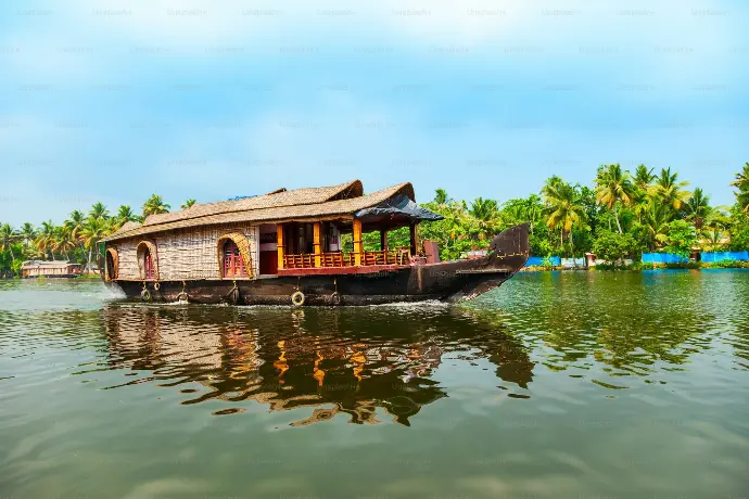 Green palm-lined canal of Kerala backwaters at sunrise - Mountain Junkey